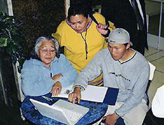 Photo de Tommy Akulukjuk, de Pangnirtung (Pangnirtuuq), montrant comment afficher les photographies archivées sur l'ordinateur, Ottawa, novembre 2002