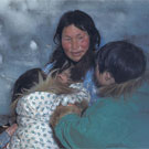 Photo d'une femme et de deux enfants inuits cuisinant dans leur igloo, Arviat (anciennement Eskimo Point) ou peut-être dans l'Ouest de Arctique, Nunavut, 1937