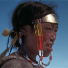 Photo couleur d'une femme inuite, Aheamuit, plissant les yeux à cause du soleil, Arviat (anciennement Eskimo Point), Nunavut, 1936