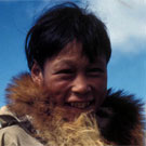 Photo couleur d'un garçon inuit vêtu d'un parka avec un collet en fourrure, Arviat (anciennement Eskimo Point), Nunavut, 1936