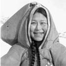 Photo d'une jeune femme inuite debout dans la neige, lieu inconnu, Nunavut, sans date