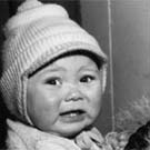 Photograph of a  young Inuit woman holding her crying infant, Iqualuit (formerly Frobisher Bay), Nunavuat, circa 1950s